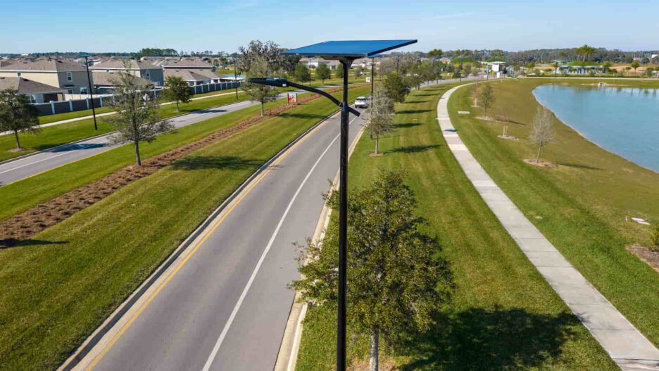 Solar-powered streetlights along a Florida roadway and lakeside path, providing resilient off-grid lighting for communities and evacuation routes.