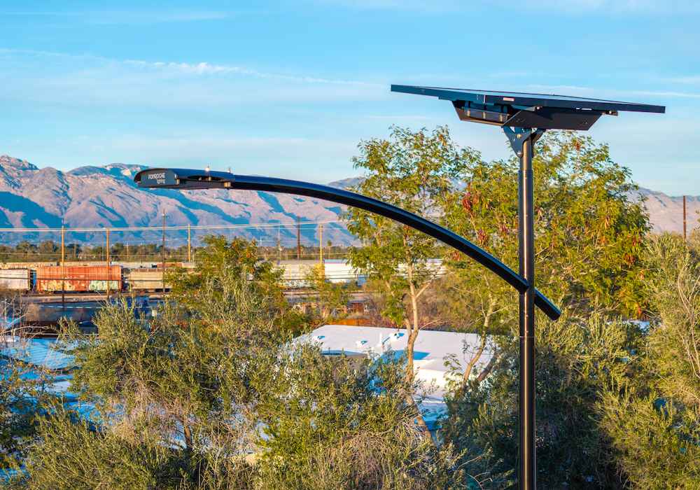 Fonroche solar streetlight providing grid-free illumination with a backdrop of mountains and trees, showcasing sustainable lighting technology