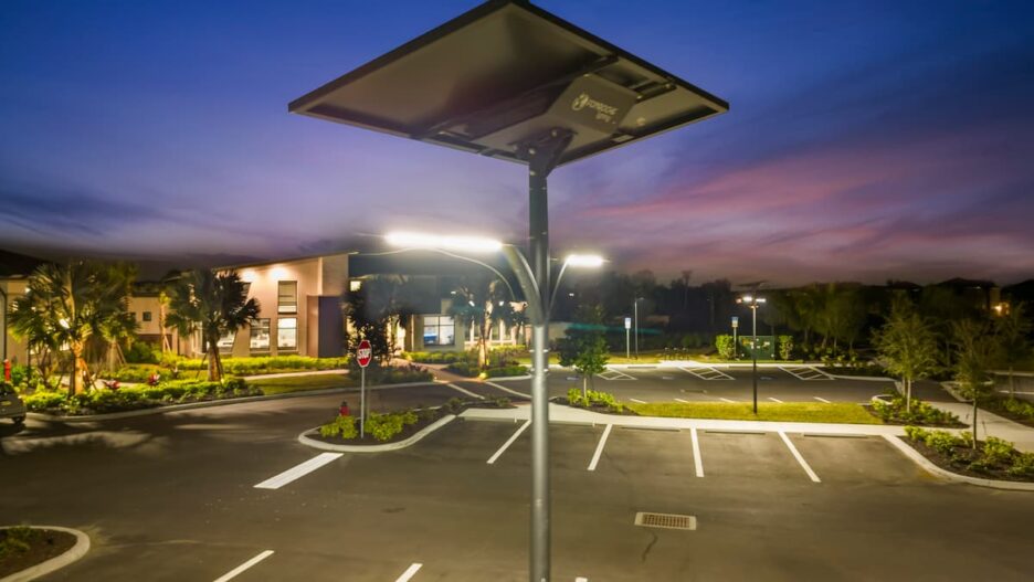 Solar-powered streetlight illuminating a Florida parking lot at dusk with reliable off-grid lighting funded through grants