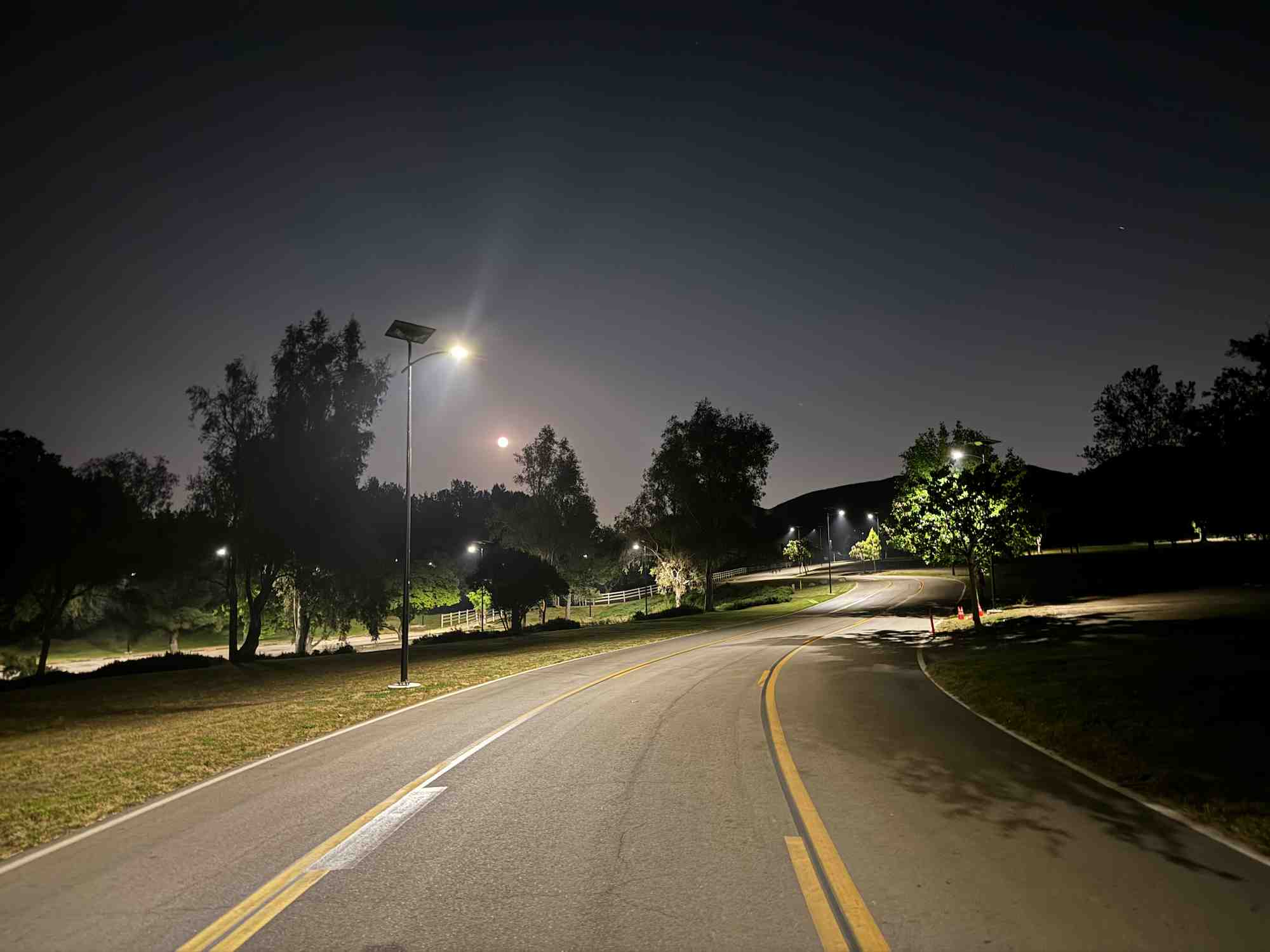 Solar-powered streetlights illuminating a California roadway at night with sustainable LED lighting