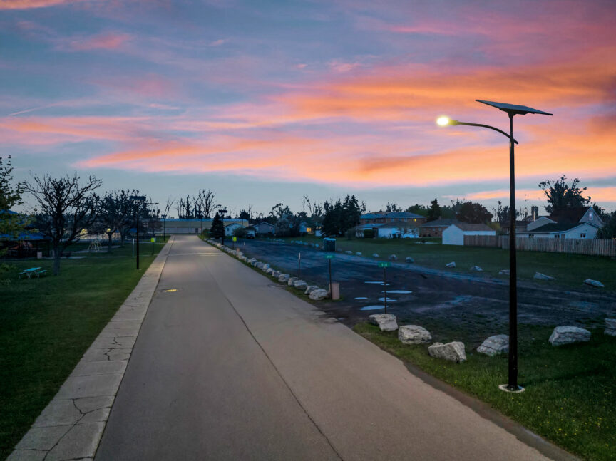 Trenchless solar streetlights illuminating a Georgia park trail at sunset, enhancing visibility and safety without relying on the electric grid.