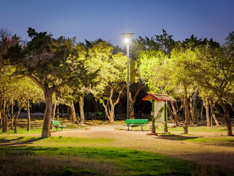 Fonroche SmartLight solar streetlight brightens a wooded park clearing at night, providing safe, sustainable illumination with zero utility grid connection.