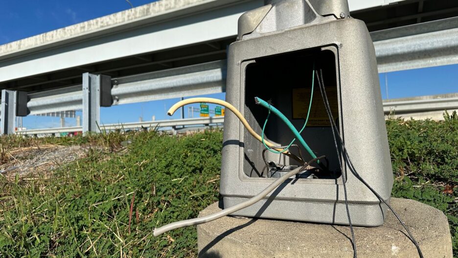 Open roadside electrical junction box with exposed and severed wires, illustrating infrastructure damage from copper theft in Georgia.