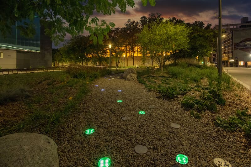 Nowatt Crystal solar studs softly illuminating a gravel walkway at night, showcasing low-impact, off-grid architectural lighting for parks, trails, and pedestrian pathways.