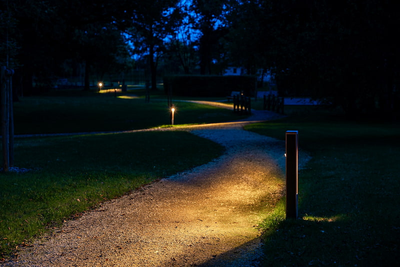 Self powered pathway and landscape lights illuminating a plam lined street at night in georgia 