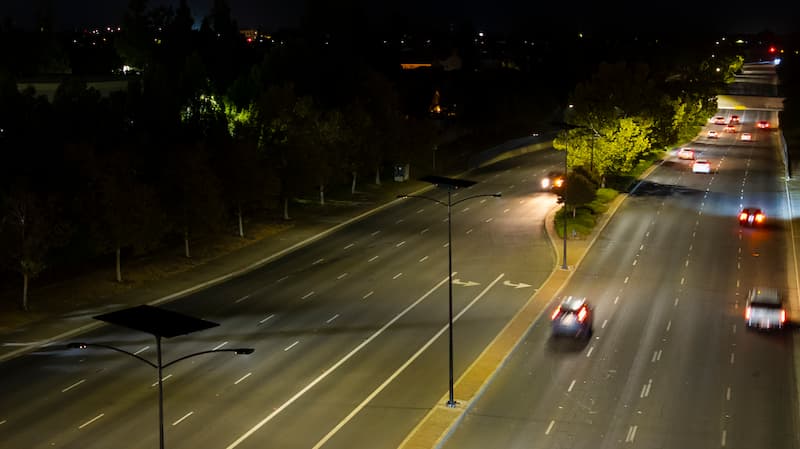 Solar street lights providing safety for drivers and pedestrians on a city road.