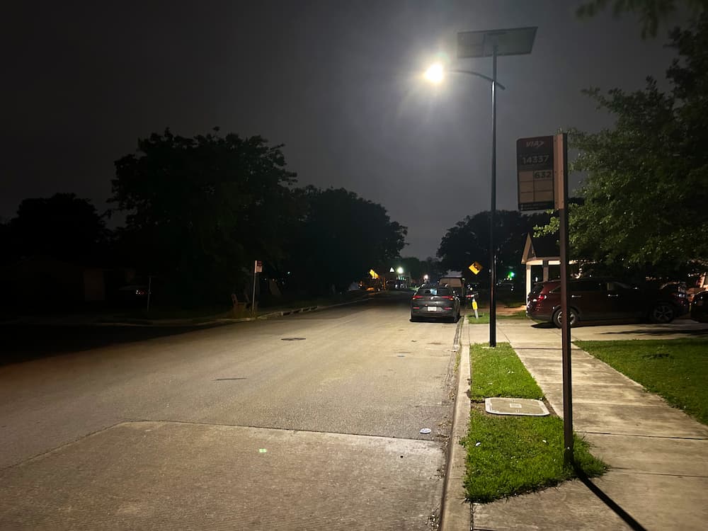 Camelot neighborhood roadway in Bexar County illuminated by new solar street lighting at night.