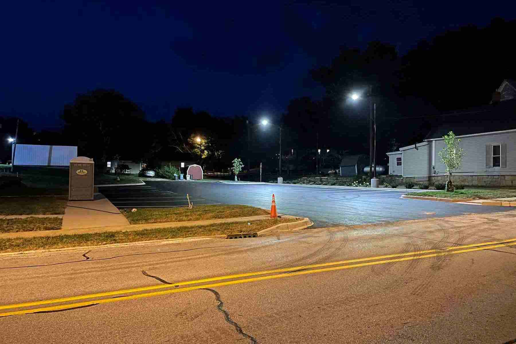 Solar streetlights illuminating a small-town parking lot and adjacent road in South Carolina, enhancing nighttime visibility for pedestrians and drivers.