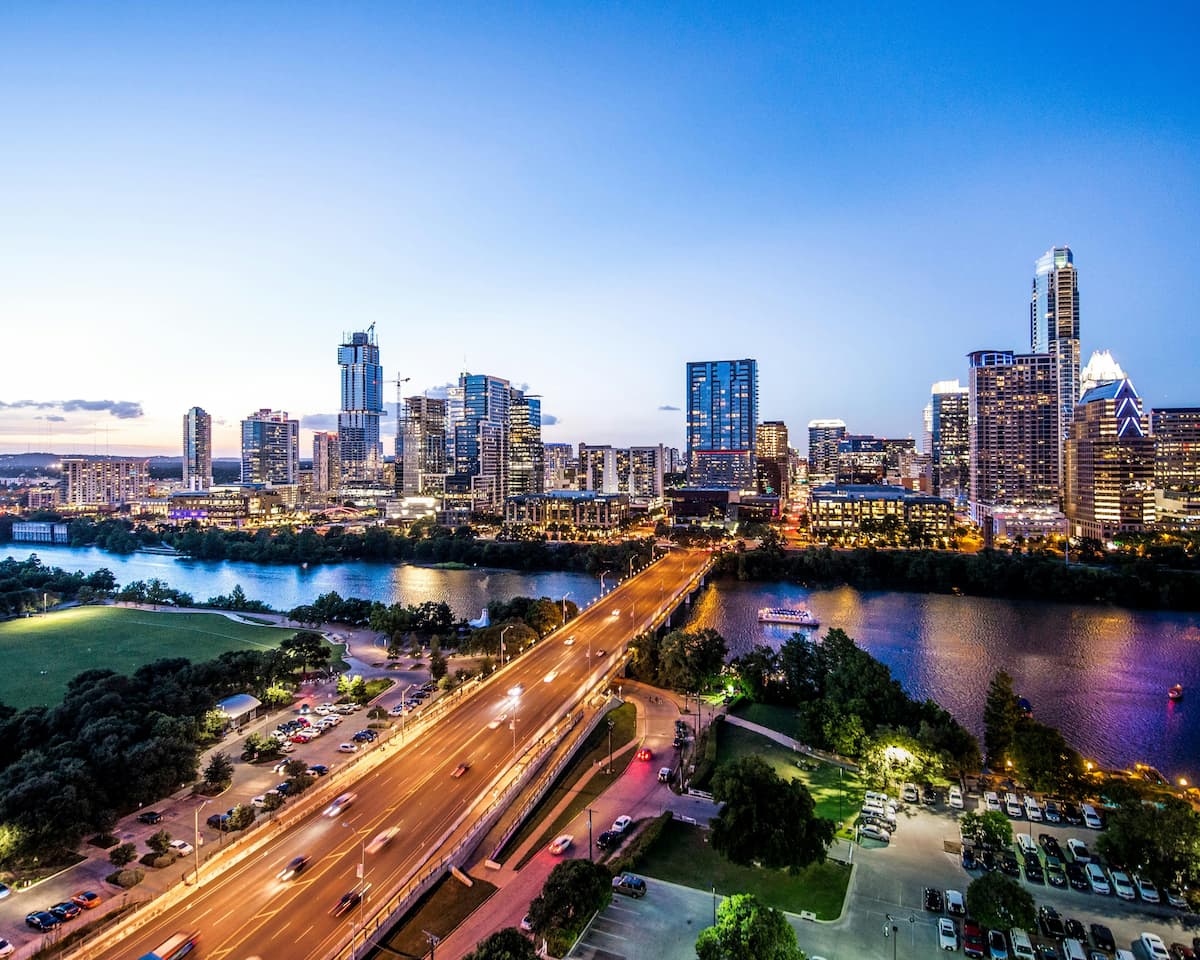 Solar-powered streetlights along a Florida city road and community park with palm trees at dusk, no grid connection required