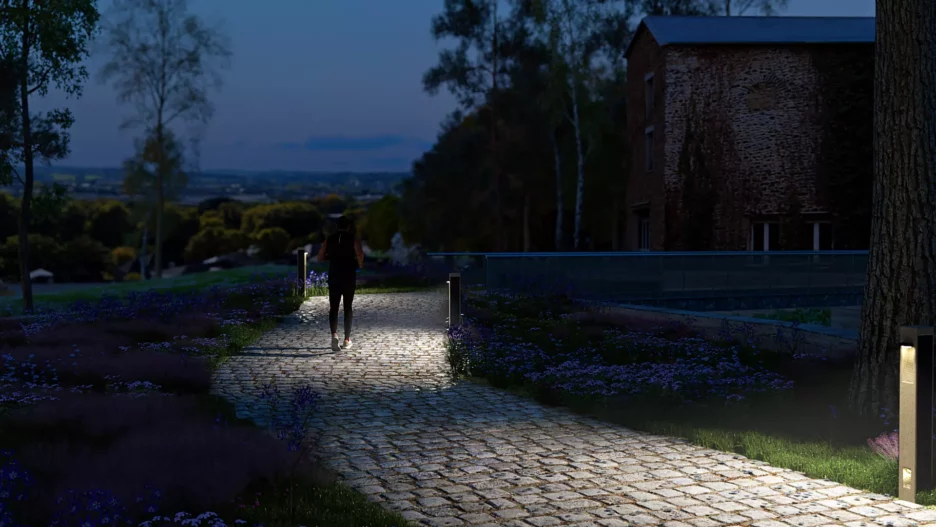 Solar bollard lights illuminating a cobblestone path at night, providing safe and sustainable walkway lighting.